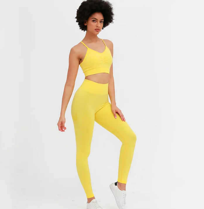 Woman wearing a yellow sports outfit on a white background